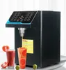 A black fructose quantitative machine is shown dispensing liquid into a glass, with two glasses of juice and some fruit in the foreground. Náhled obrázku produktu