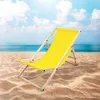 A yellow deck chair sits on a sandy beach with the ocean and sky in the background. Náhled obrázku produktu