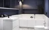 A modern bathroom with a white vanity, sink, and bathtub against dark blue walls. Produktbild-Vorschau