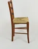 A side view of a wooden chair with a woven seat. Produktbild-Vorschau