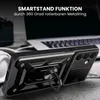 A black smartphone case with a ring stand is shown in a close-up shot, with a laptop and headphones blurred in the background. Produktbild-Vorschau
