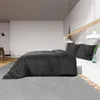A bedroom scene with a bed, nightstand, and chair. Voir les images du produit