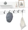 A white wall-mounted shelf with hooks, holding decorative items and accessories. Voir les images du produit