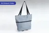A gray shopping trolley bag with black handles and a black zipper detail, shown against a light gray and white background. Náhľad obrázku produktu
