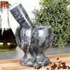 A marble mortar and pestle are shown on a wooden cutting board, with a bottle of olive oil and herbs in the background. Voir les images du produit