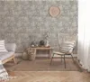 A living room scene with wallpaper, a sofa, a chair, and a rug. Produktbild-Vorschau