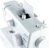 A close-up view of the top section of a white sewing machine, showing the bobbin area and some controls. Produktbild-Vorschau