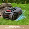A robotic lawnmower on a grassy lawn with a rock formation in the background. Produktbild-Vorschau