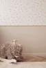 A fluffy mammoth rocking toy is placed on a rug in a room with a dotted wallpaper. Produktbild-Vorschau
