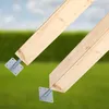 Two wooden beams are attached to metal post bases, set against a blurred background of green grass and a light blue sky. Produktbild-Vorschau