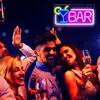 A group of friends are celebrating and toasting drinks in a bar, with a neon sign that says 'BAR' above them. Voir les images du produit