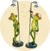 Two frog figurines are shown showering under a shower head. Produktbild-Vorschau