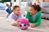Two young girls are lying on the floor, playing with a toy kitten. Podgląd zdjęcia produktu