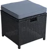 A black polyrattan storage ottoman with a gray cushion on top, shown from a slightly angled front view on a white background. Produktbild-Vorschau
