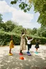 Four people, including children, are balancing on colorful stepping stones in a park. Voir les images du produit