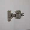 A close-up of a cabinet hinge on a white surface. Anteprima dell’immagine prodotto