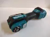 A Makita DTM52Z Akku-Multitool is shown on a white and light gray surface. Produktbild-Vorschau