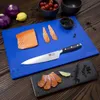 A cutting board with salmon and ingredients on a wooden table. Anteprima dell’immagine prodotto