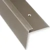 A close-up, angled view of a bronze-colored stair nosing profile against a white background. Podgląd zdjęcia produktu