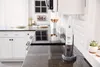 A handheld vacuum cleaner is shown on a kitchen counter. Produktbild-Vorschau