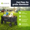 A black Juskys wagon filled with items and a white puppy, set on a grassy lawn with tents in the background. Náhled obrázku produktu