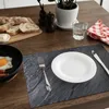 A breakfast setting on a wooden table with bread, butter, fried egg, sausages, a plate, cutlery, and a glass of water. Anteprima dell’immagine prodotto