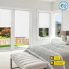A bedroom with large windows covered by white roller blinds. Produktbild-Vorschau