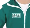 Close-up of a green tracksuit with white trim and a white rectangle containing the number '0457' on the chest. Produktbild-Vorschau
