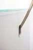 A close-up shot of a white cabinet with a slot, and a brown object inserted into it. Produktbild-Vorschau
