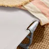 Close-up of a beach chair with a striped towel and a straw hat. Voir les images du produit
