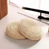 Two round woven cushions are placed on a light-colored floor, with a sword on a stand in the background. Produktbild-Vorschau