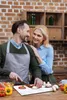 A couple is in a kitchen preparing food together. Produktbild-Vorschau