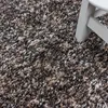 A close-up view of a shaggy rug with a white chair leg in the corner. Náhled obrázku produktu