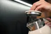 A person is holding the lid of a cream-colored electric kettle. Podgląd zdjęcia produktu