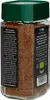 A close-up side view of a glass jar filled with instant coffee granules, with a green lid and a black label featuring text and logos. Produktbild-Vorschau