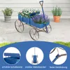 A blue wooden wagon planter filled with flowers, shown on a patio with other plants in the background. Below are close-up shots highlighting product features. Produktbild-Vorschau