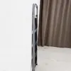 A folded metal ladder leaning against a white wall, with a brown curtain in the background. Náhled obrázku produktu