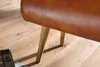 A close-up shot of the legs and underside of a brown leather bench on a wooden floor. Náhľad obrázku produktu