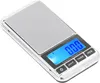 A small, portable digital scale with a silver casing and a blue LCD screen showing '0.00'. The screen also displays 'Capacity: 300gx0.01g'. Buttons for 'UNIT', 'TARE', and 'PCS' are visible below the screen. Voir les images du produit