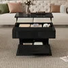 A black coffee table with storage is shown in a living room setting, in front of a sofa. Produktbild-Vorschau