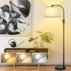 A modern living room scene with a floor lamp, artwork, and a cabinet. Anteprima dell’immagine prodotto