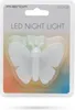 A white butterfly-shaped LED night light is packaged in a clear plastic blister pack on a cardboard backing with a gradient of colors. Produktbild-Vorschau
