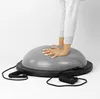 A person's hands are resting on a gray balance trainer with black resistance bands attached. Anteprima dell’immagine prodotto