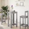 A bar table and two bar stools are set up in a room with a plant and shelves on the wall. Produktbild-Vorschau