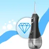A black and silver water flosser is shown against a light blue and white background with abstract shapes and a diamond icon. Voir les images du produit