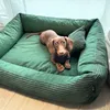 A brown dachshund dog is lying on a green dog bed. Náhled obrázku produktu