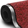 A close-up view of a rolled-up red and black speckled doormat, showing the textured surface and the rubber backing. Produktbild-Vorschau