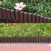 A garden border made of brown plastic palisades is shown in two different settings: one with a pink hibiscus flower and lush green foliage, and another with a dense green hedge and a pink gravel path. Voir les images du produit