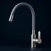 A modern kitchen faucet with a flexible gray hose and a silver handle, set against a dark background. Produktbild-Vorschau