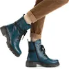 A pair of blue lace-up boots worn by a person wearing brown corduroy pants and beige socks. Voir les images du produit